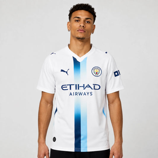 Camisa Manchester City III 2026/27 Torcedor Puma masculina branca, com faixa vertical em azul-celeste e azul-marinho criada a partir de projeto escolhido pelos torcedores. frente