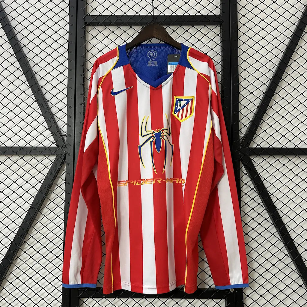 Camisa titular de manga longa do Atlético de Madrid 2004/05 vista de frente, com listras vermelhas e brancas, escudo do clube e o icônico patrocínio do filme Spider-Man 2.